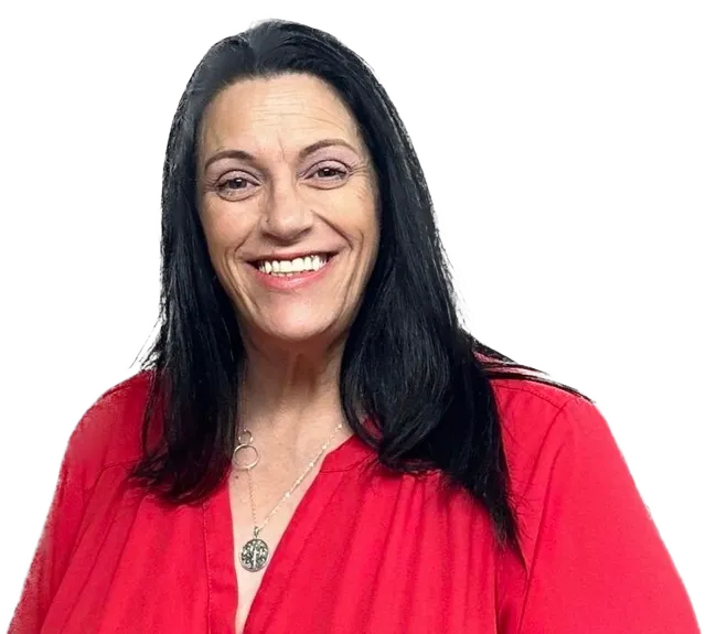 A woman in a red shirt is smiling and wearing a necklace