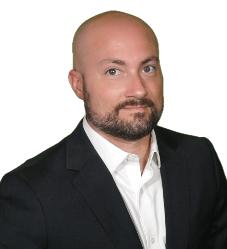 A bald man with a beard is wearing a suit and white shirt.