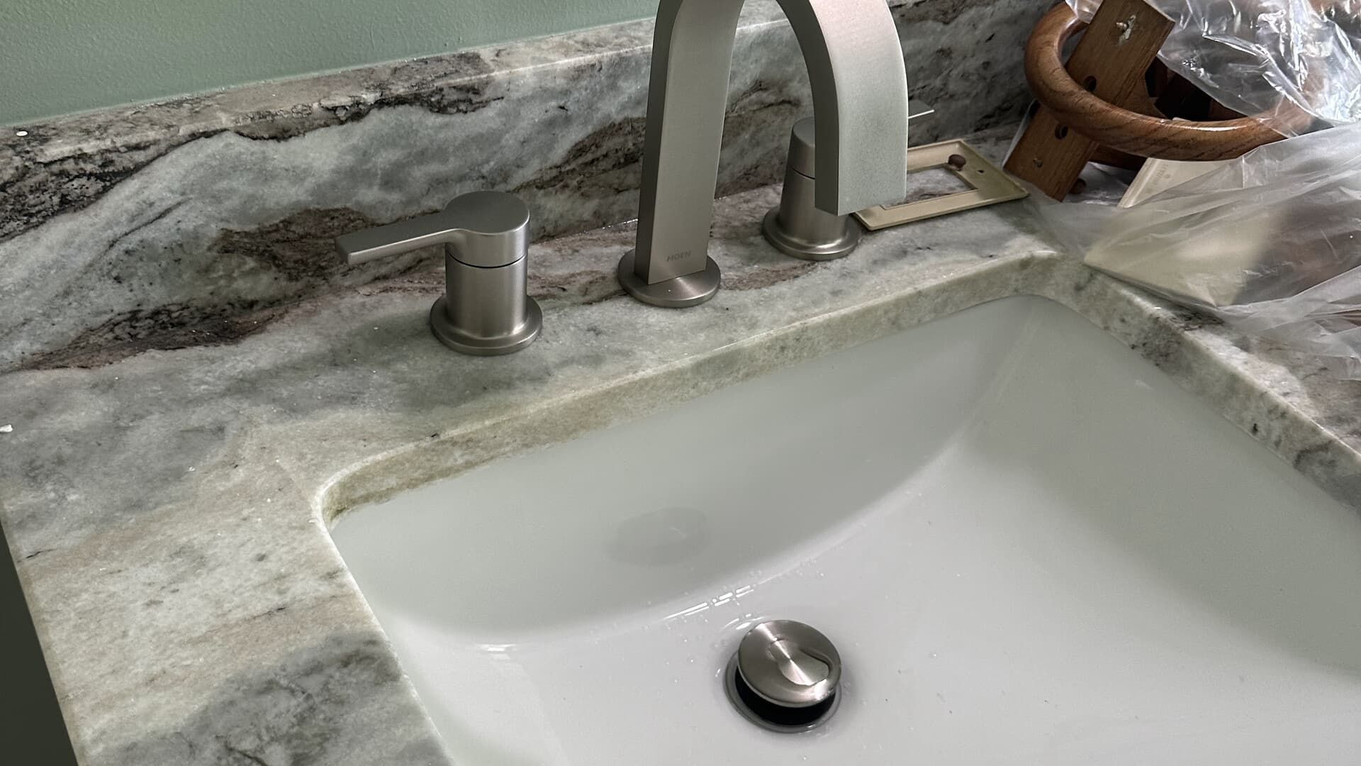 Bathroom sink with a brushed nickel faucet on a marble countertop.