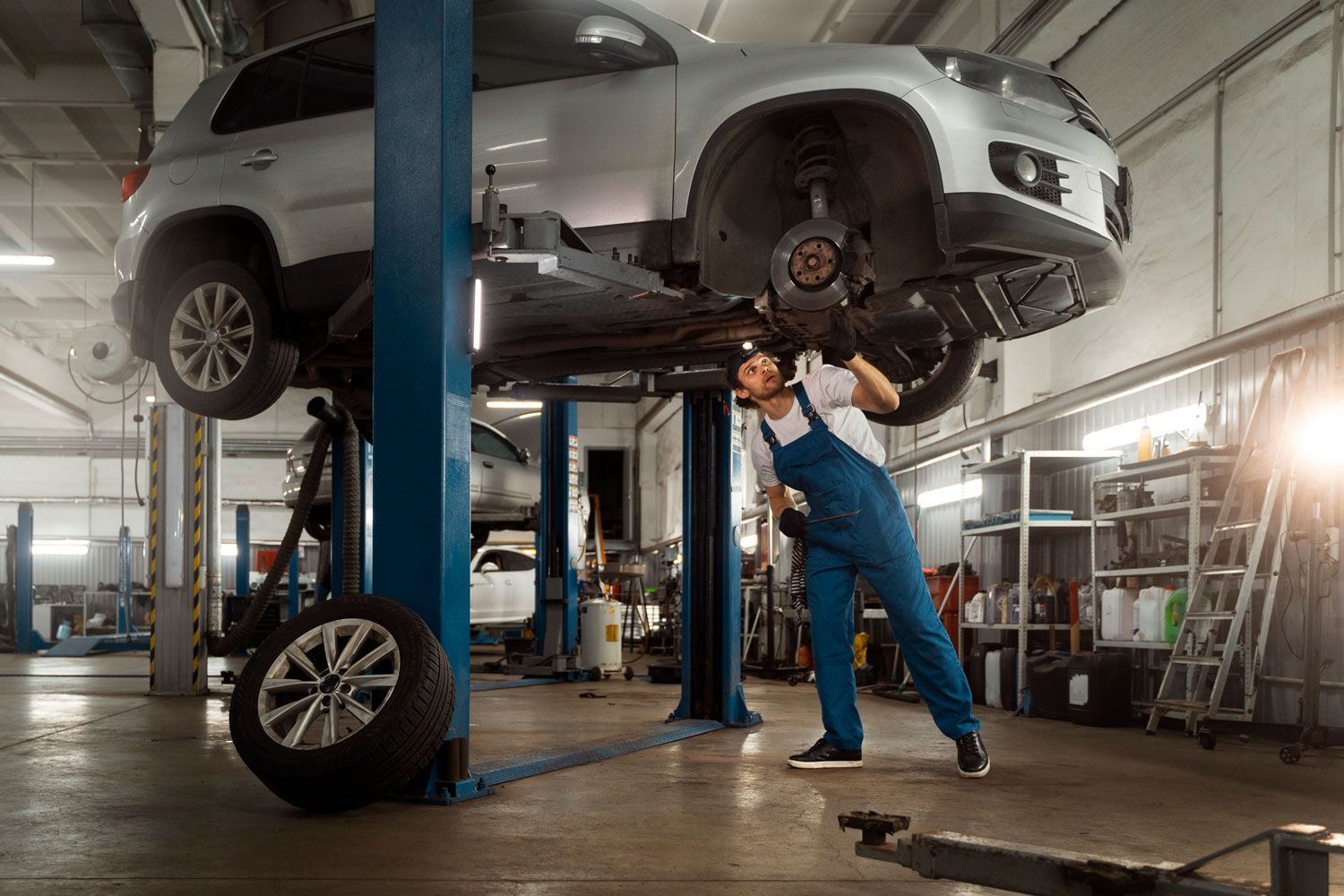 A mechanic is working on a car in a garage.
