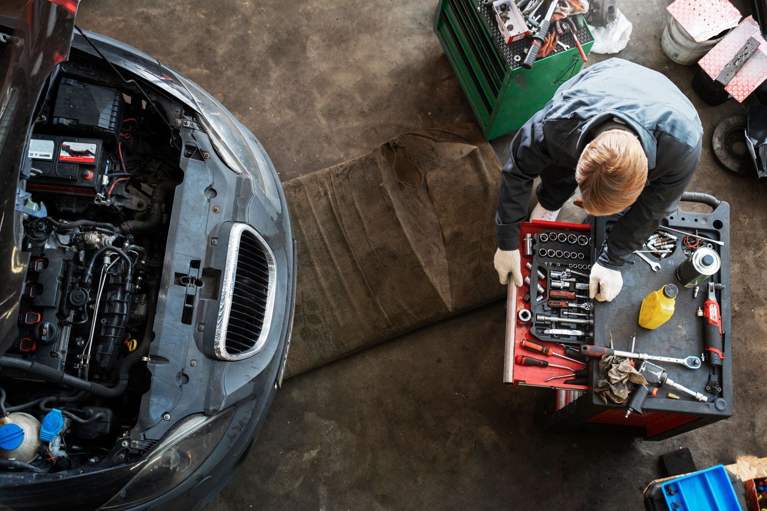 A man is working on a car in a garage.