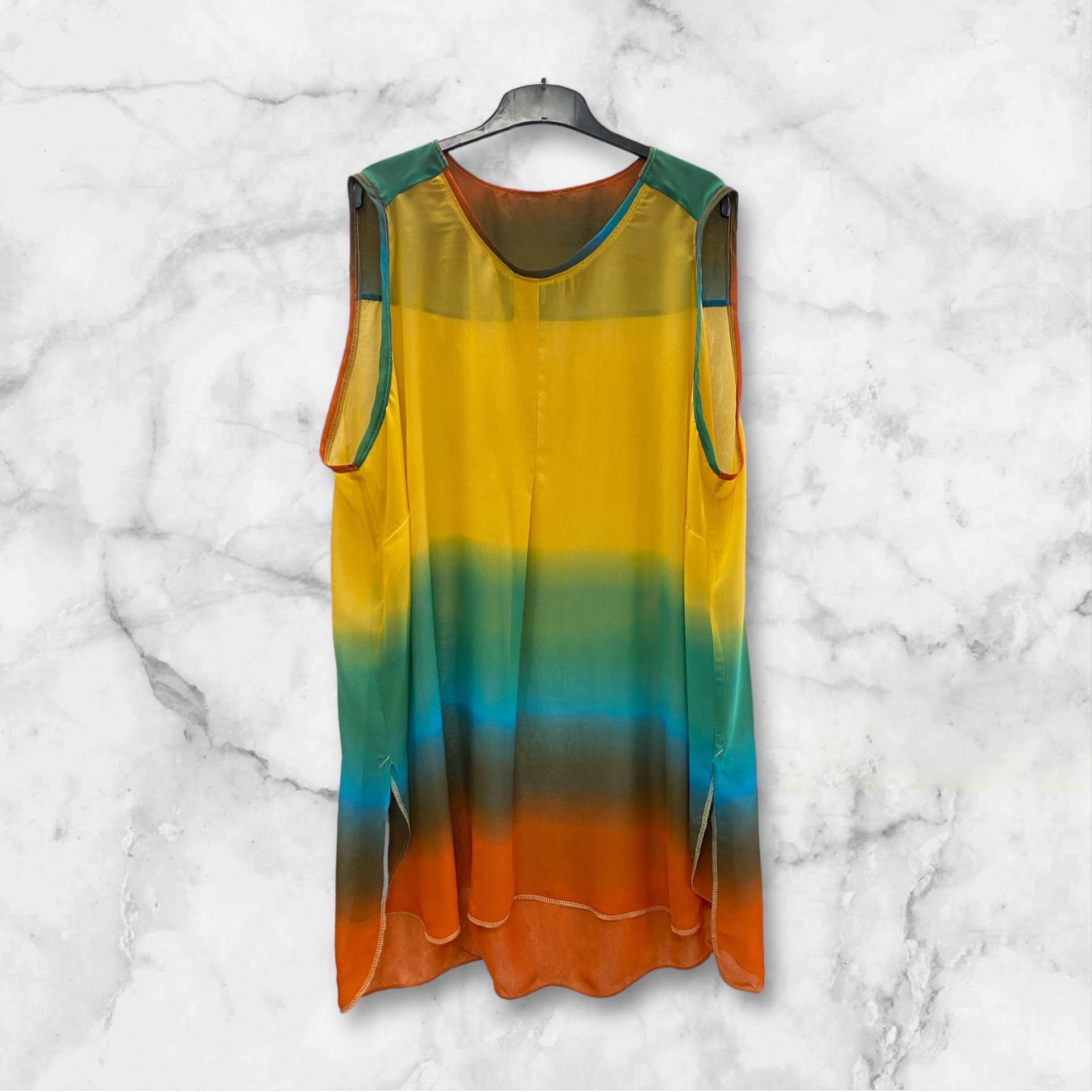 Une robe colorée est suspendue à un cintre sur une surface en marbre