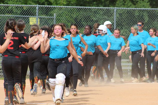 Baseball player sliding into home plate, catcher in front. Blue and gold uniforms, action shot.