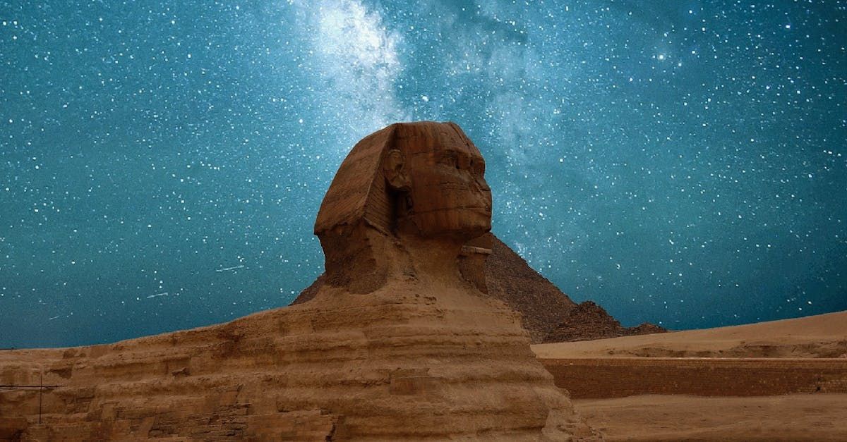 The sphinx statue is under a starry night sky.
