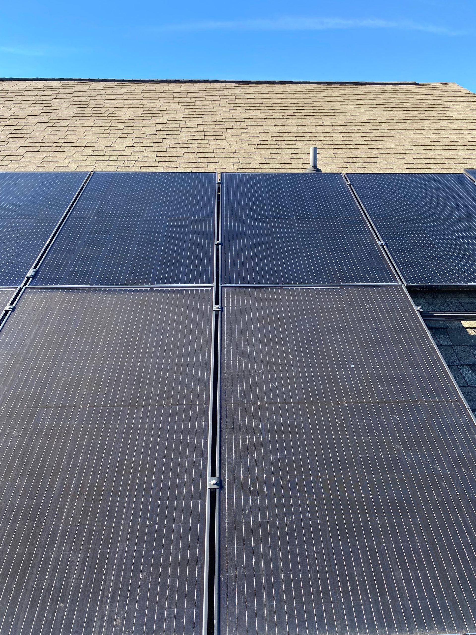Solar panels on a rooftop, with a blue sky in the background.