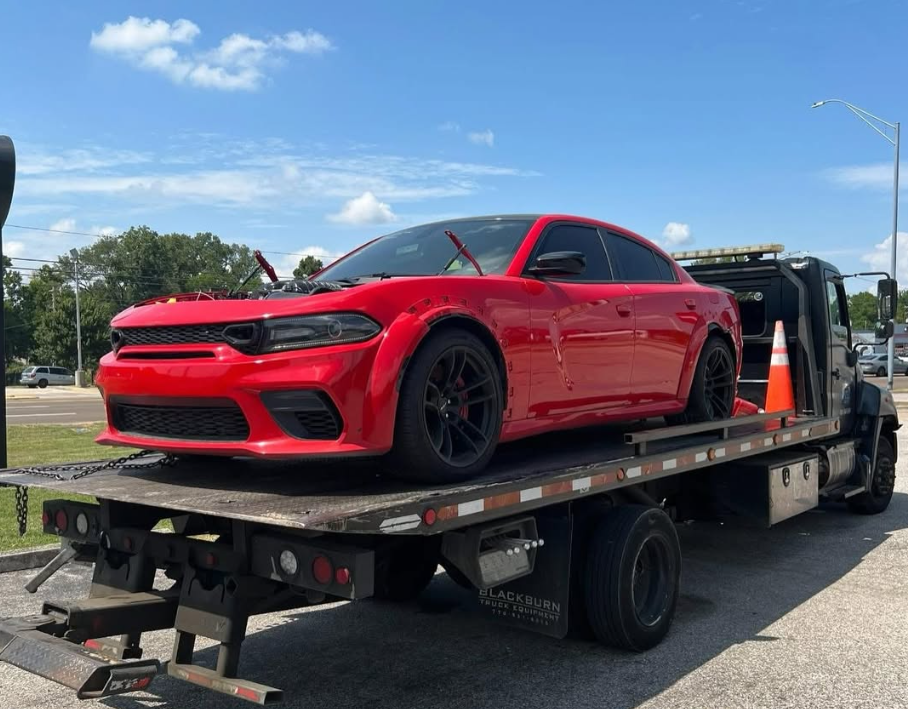 A car is being towed by a tow truck.