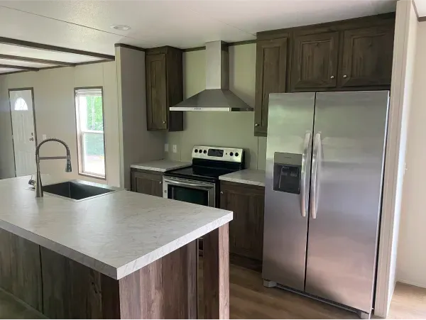 A kitchen with a stainless steel refrigerator , stove and sink.