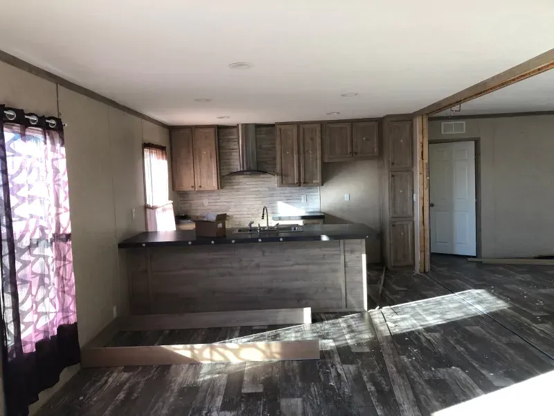 A kitchen in a mobile home with wooden cabinets and a sink.