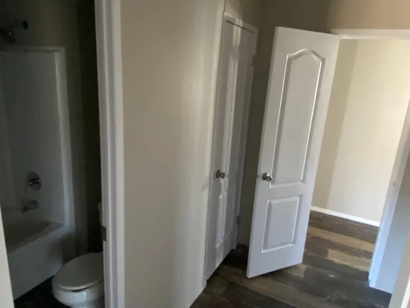 A bathroom with a toilet , bathtub and closet.