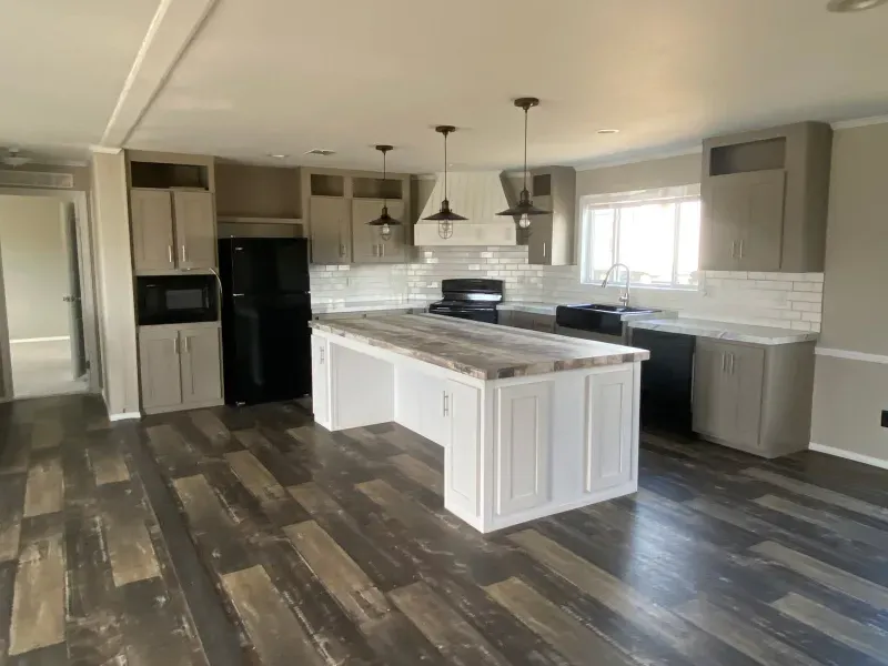 A kitchen in a mobile home with a large island in the middle.