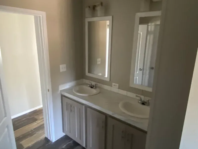 A bathroom with two sinks and two mirrors.
