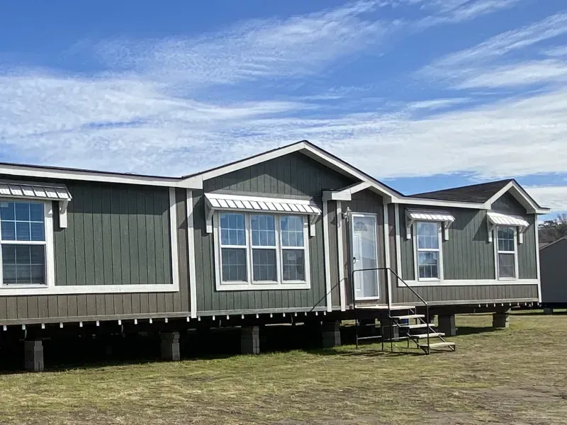 A mobile home is sitting on top of a lush green field.
