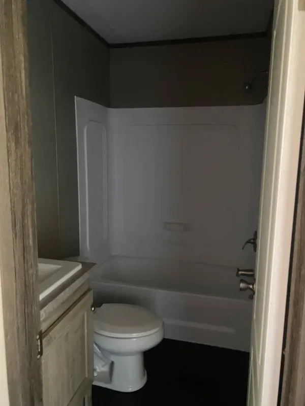 A bathroom with a toilet , sink and bathtub.