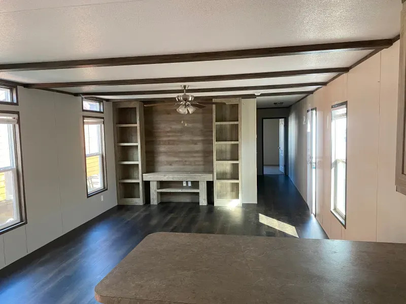 A living room in a mobile home with a built in entertainment center.