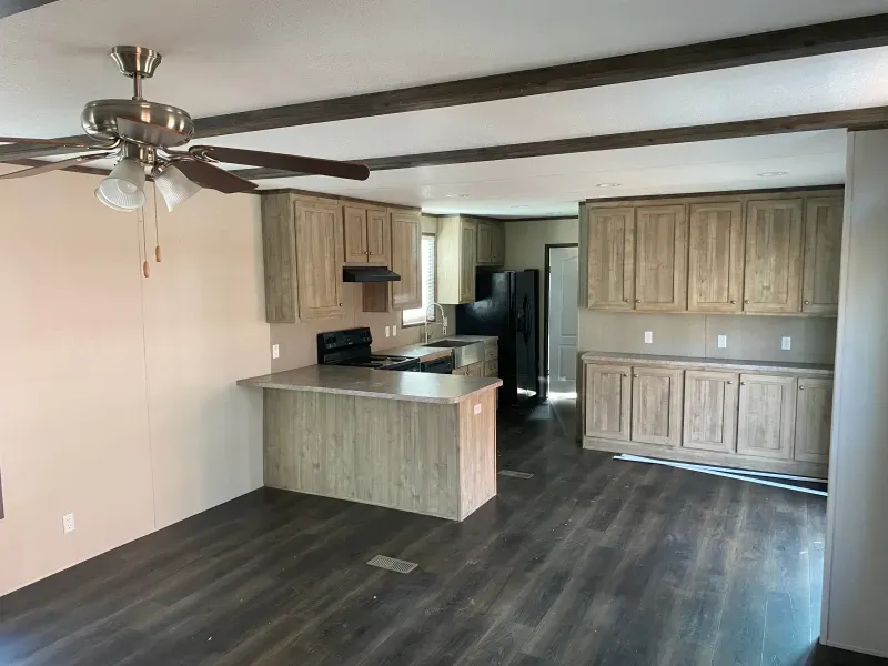 There is a ceiling fan in the kitchen and a ceiling fan in the living room.