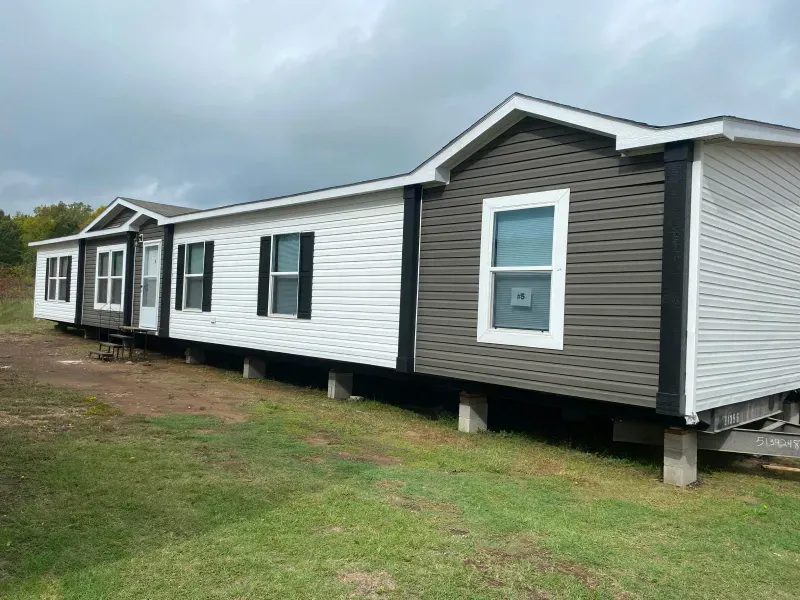 A row of mobile homes sitting on top of a lush green field.