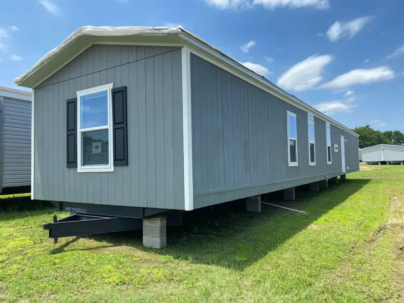 A mobile home is parked in a grassy field.