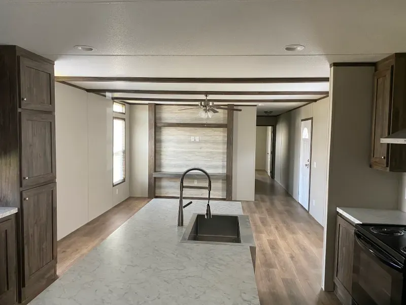 A kitchen in a mobile home with a large island and a sink.