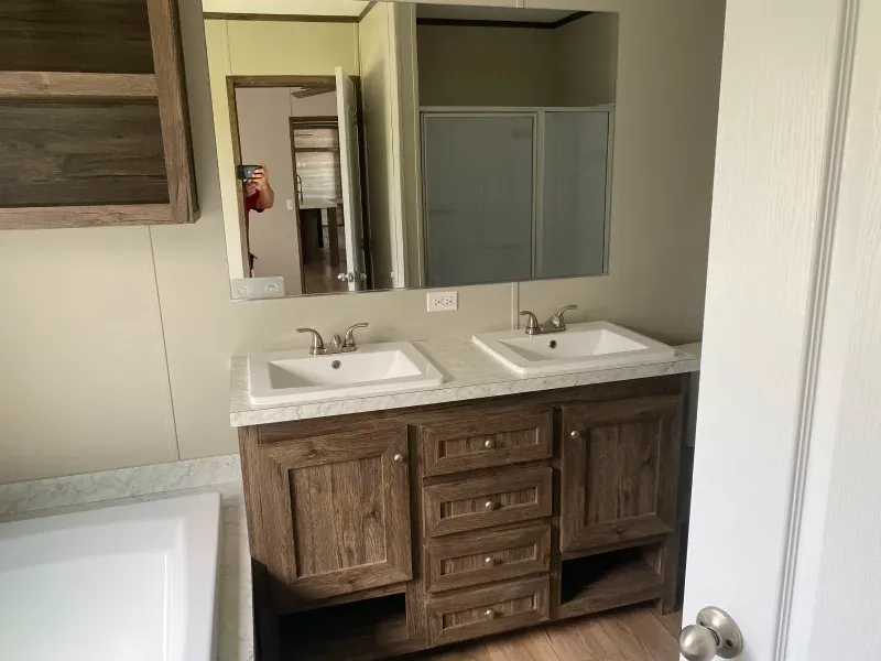 A bathroom with two sinks , a tub and a mirror.