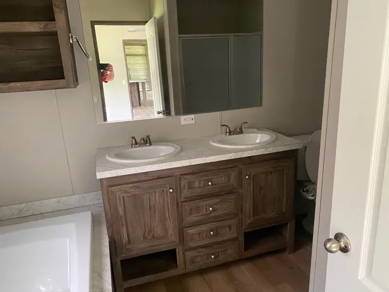 A bathroom with two sinks , a toilet , and a bathtub.