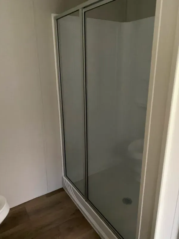 A bathroom with a walk in shower and a toilet.