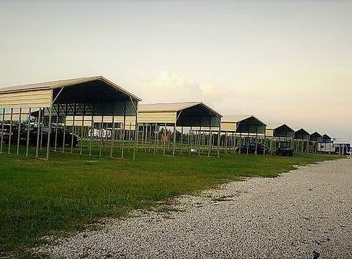 A row of buildings sitting on top of a lush green field.