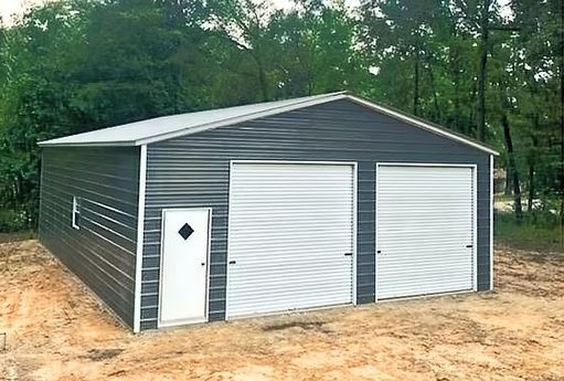 A garage with two garage doors and a door in the middle of a dirt field.