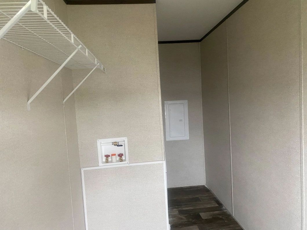 A laundry room with a washer and dryer and a shelf.