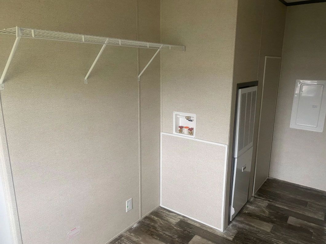 A closet with a shelf and a door in a mobile home.