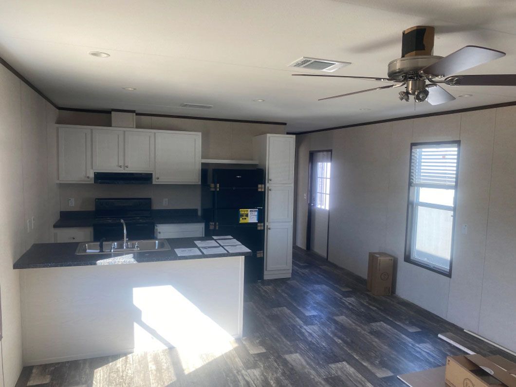 A kitchen in a mobile home with a ceiling fan