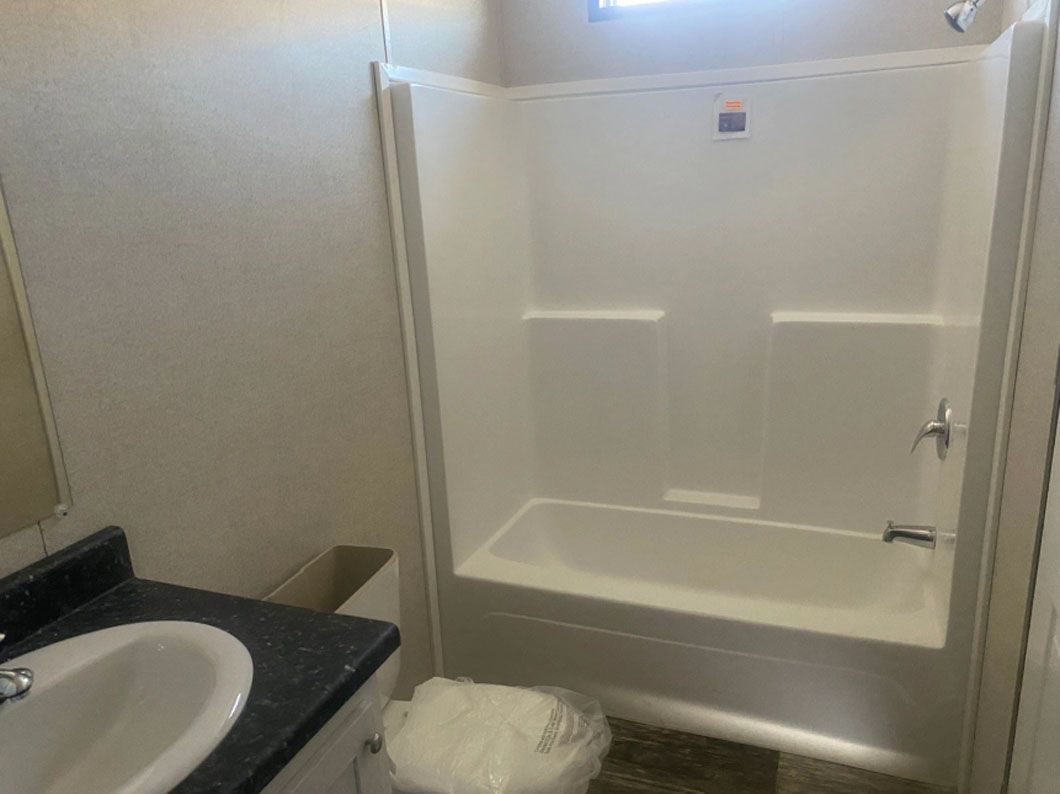 A bathroom with a tub , sink , and shower.