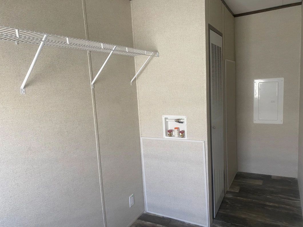 A closet with a shelf and a door in a mobile home.