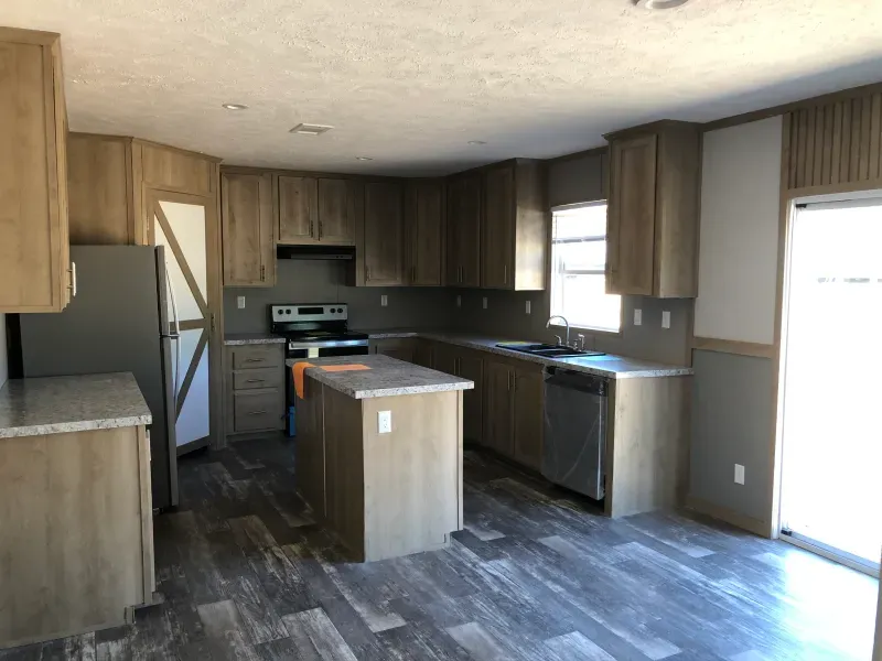 A kitchen with wooden cabinets , stainless steel appliances , and a large island.