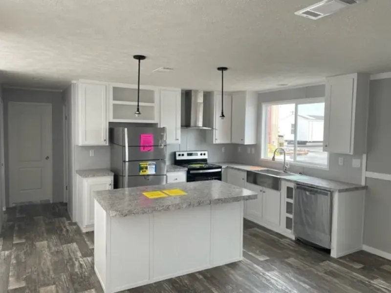 A kitchen with white cabinets , stainless steel appliances , and a large island.