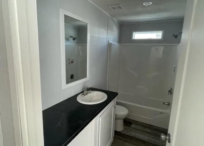 A bathroom with a sink , toilet , tub and mirror.