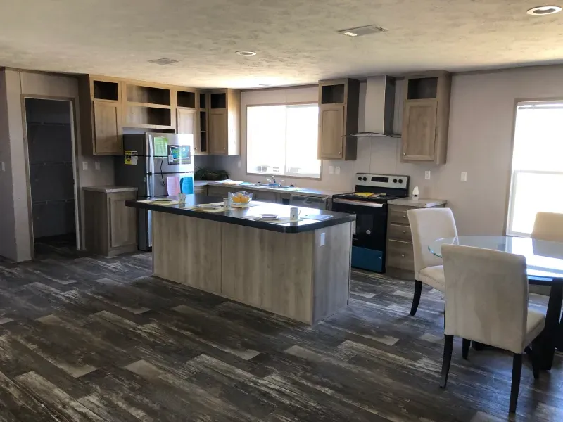 A kitchen with a large island in the middle and a table and chairs.