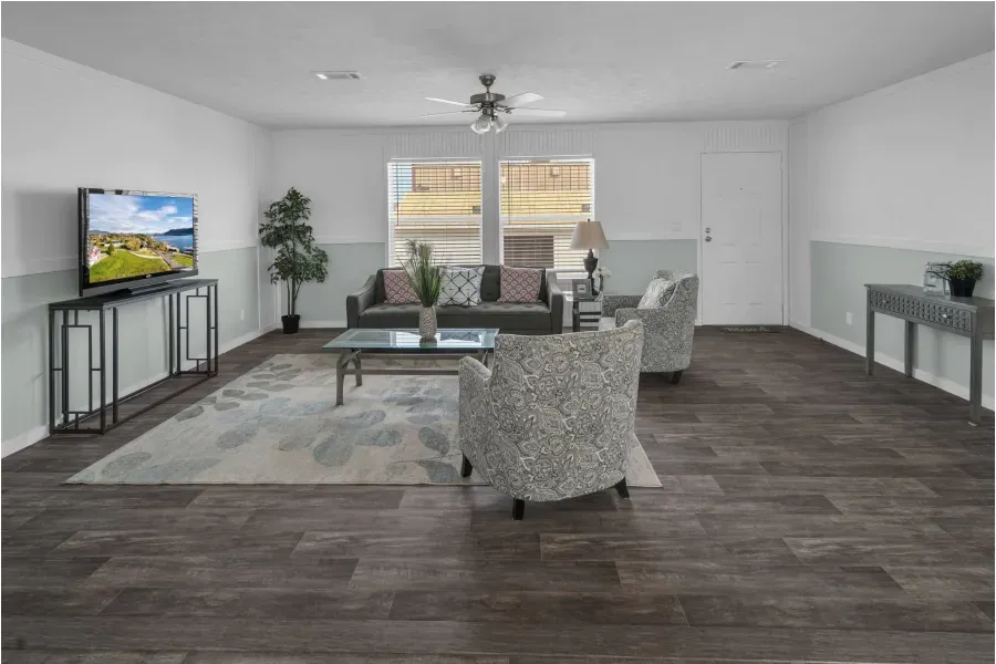 A living room with a couch , chairs , and a television.
