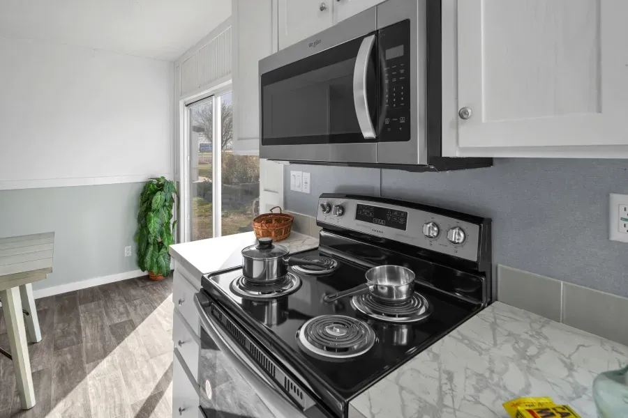 A kitchen with a stove , microwave , and oven.