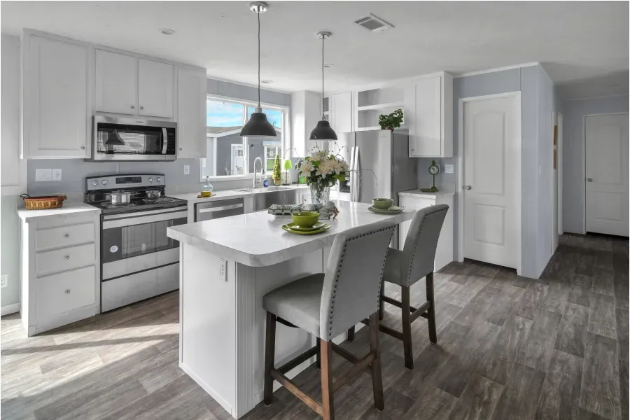 A kitchen with white cabinets , stainless steel appliances , and a large island.