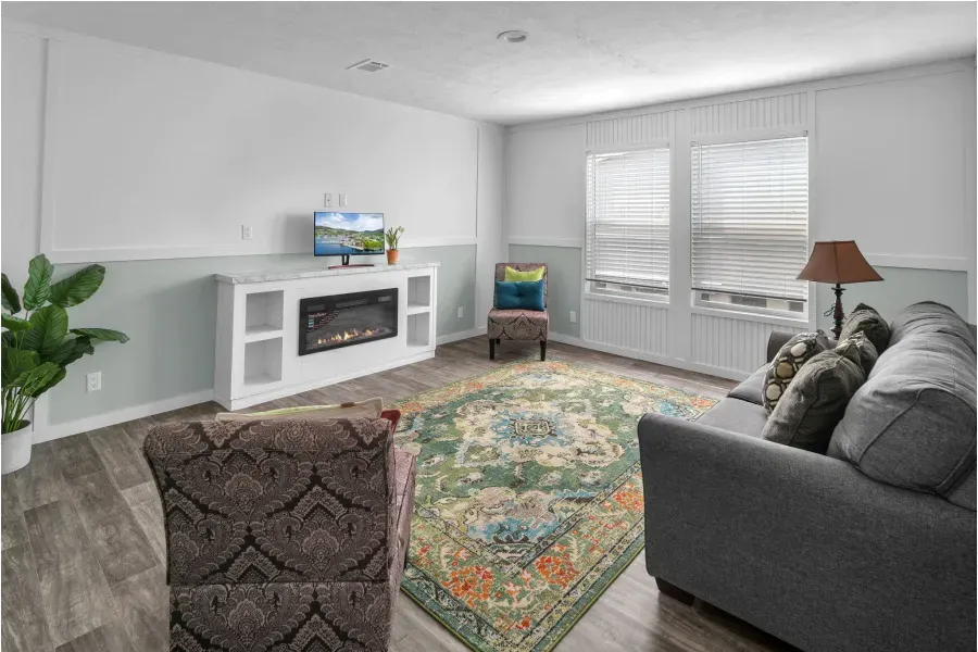 A living room with a couch , chair , fireplace and television.