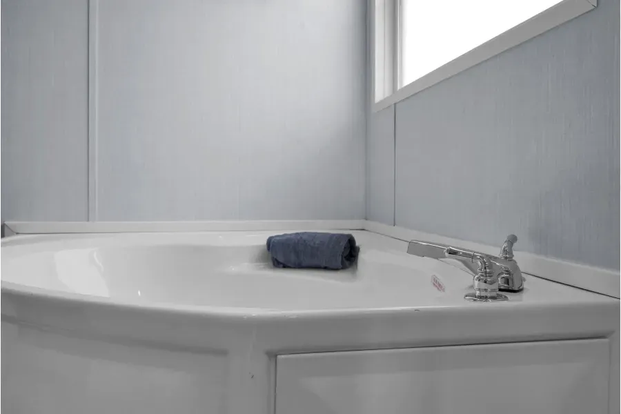 A bathtub with a towel on top of it in a bathroom next to a window.