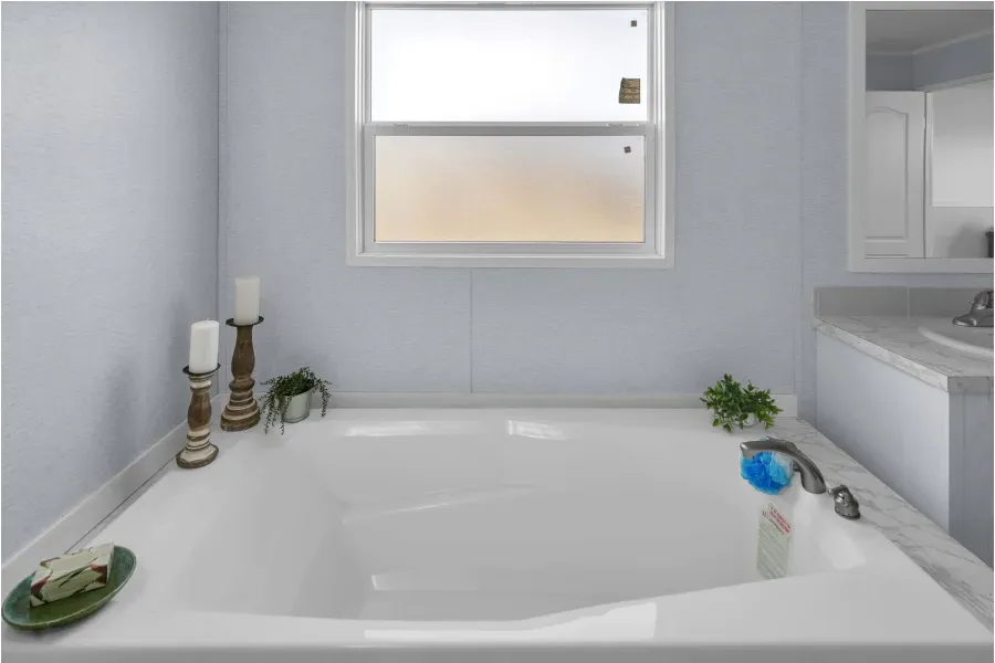 A bathroom with a large bathtub and a window.
