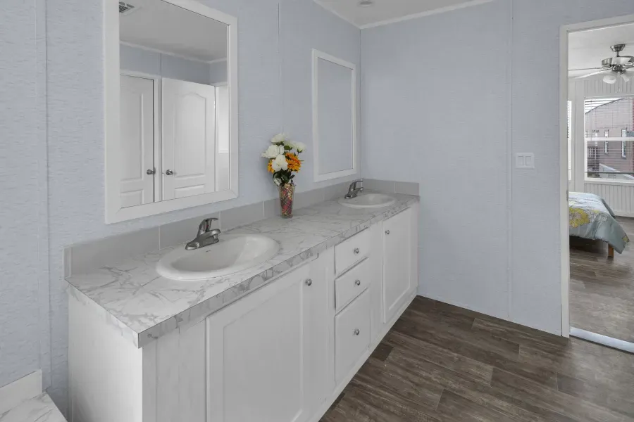 A bathroom with two sinks and a mirror.