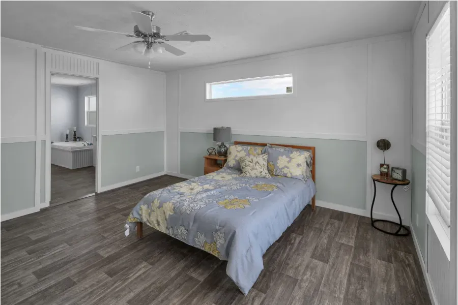 A bedroom with a bed , nightstand , and ceiling fan.