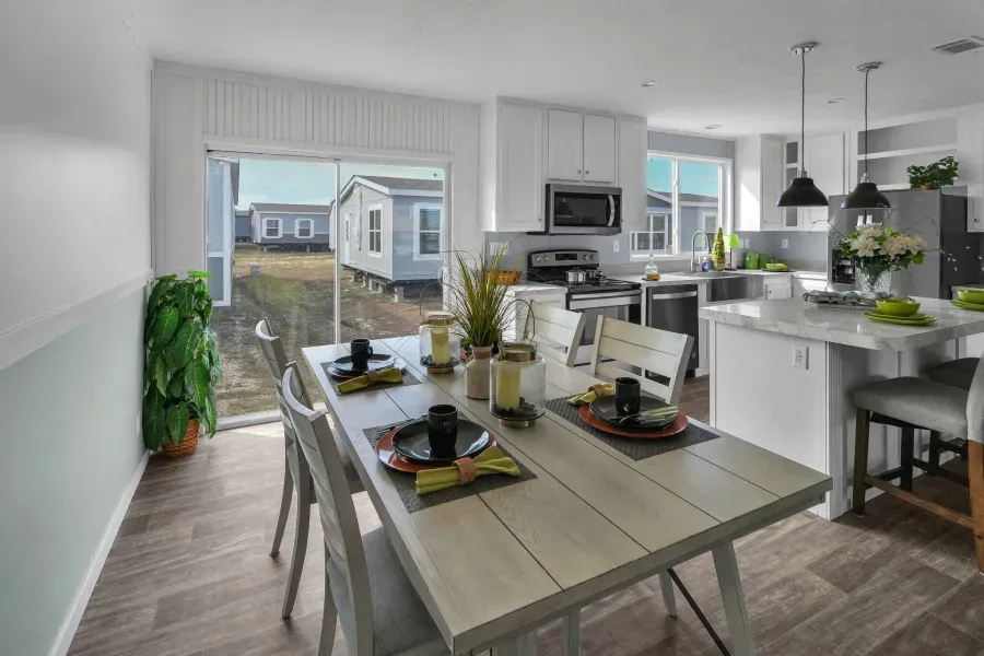 A dining room with a table and chairs in a mobile home.