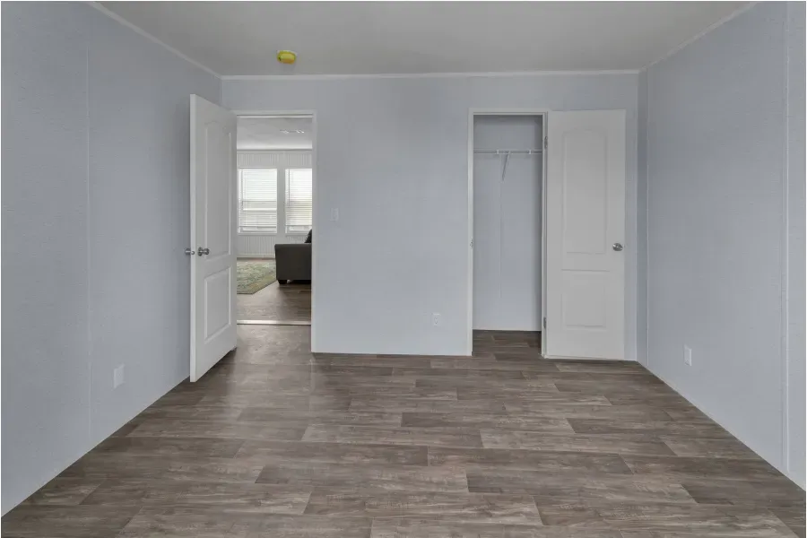 An empty room with hardwood floors and white walls