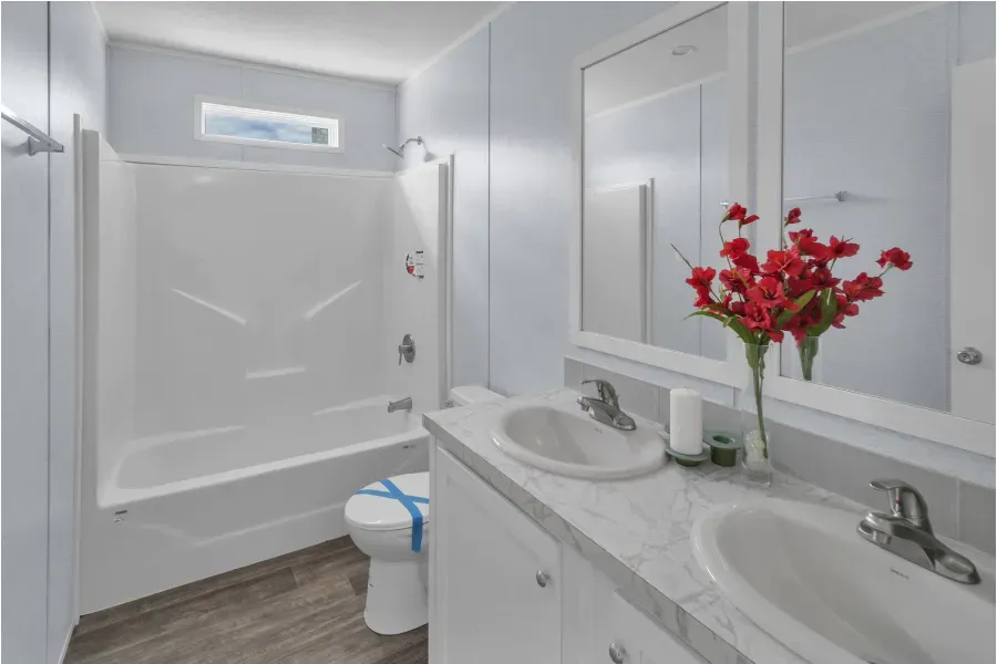 A bathroom with a sink , toilet , bathtub and mirror.