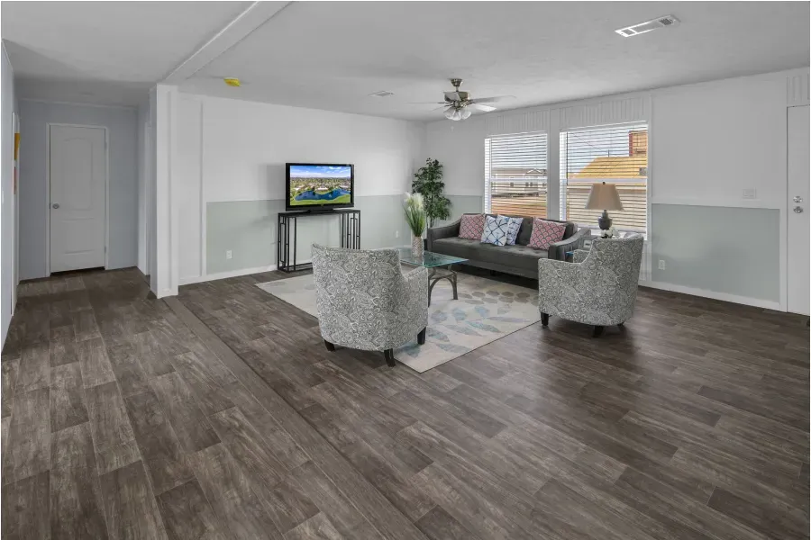 A living room with a couch , chairs , and a television.