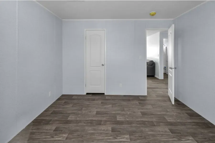An empty room with a wooden floor and white walls.