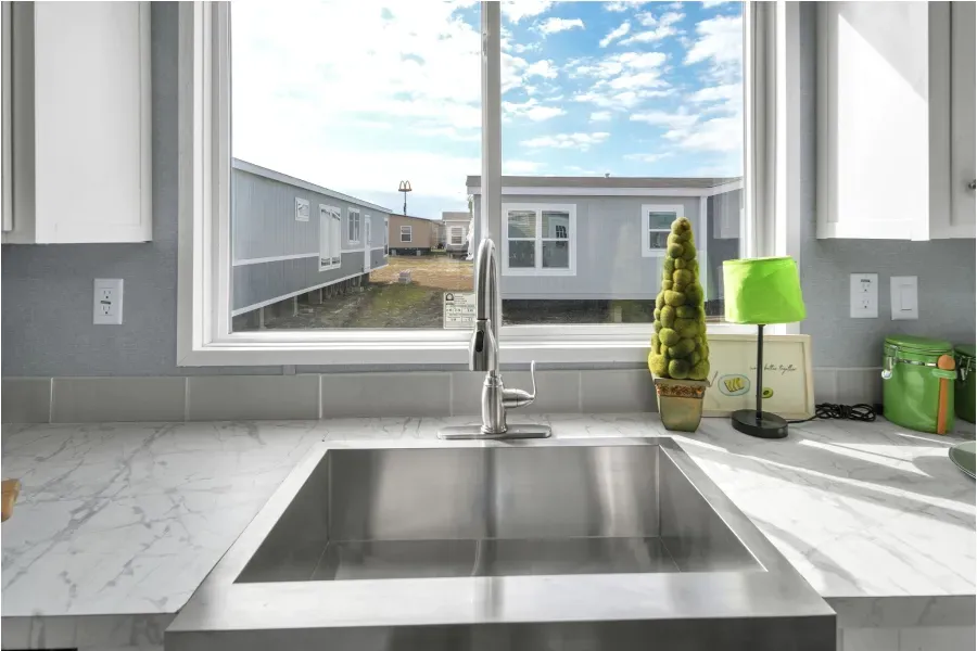 A kitchen with a stainless steel sink and a window